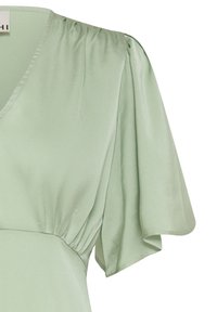 Robe en satin vert clair avec col en V, buste froncé, manches courtes à volants et couture lisse à la taille.