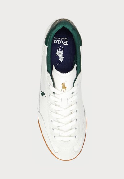 Baltas sneakers ar zaļiem akcentiem, ar zeltītu logotipu, auklu dizainu un gumijas zoli, gludu tekstūru un izšūtām detaļām.