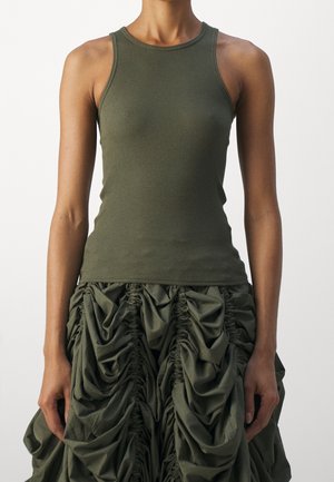 Camiseta sin mangas de canalé en verde oliva combinada con una falda voluminosa en verde oliva con detalles de tela fruncida y plisada.