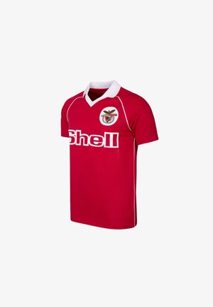 Rotes Fußballtrikot mit kurzen Ärmeln, weißem Kragen, weißen Paspeln, Shell-Sponsorlogo und rundem Mannschaftswappen mit Adler auf der Brust.