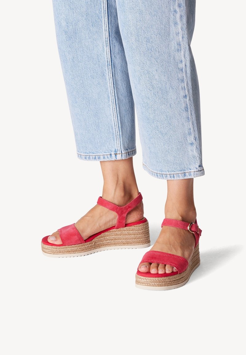Červené semišové wedges sandály s kotníkovým páskem, přírodní provázkovou dekorací a bílou gumovou podrážkou. Design s otevřenou špičkou a nastavitelným sponou.