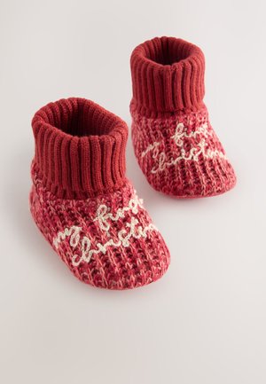 Raudonos ir rožinės megztos bateliai su ribotu rankogaliu, ant kurių siuvinėta balta "mano pirmos Kalėdos". Minkšta tekstūra ir jaukus dizainas.