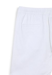 Shorts bianchi in cotone con vita elastica e una tasca posteriore con dettaglio di bordo cucito. Texture liscia e design casual.