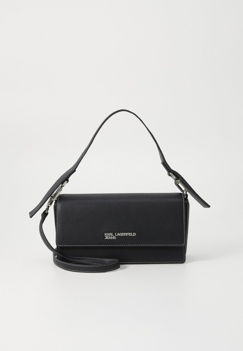 Borsa a tracolla nera in pelle con una forma strutturata, dotata di una tracolla rimovibile, accessori in argento e cuciture bianche. Logo ben visibile.
