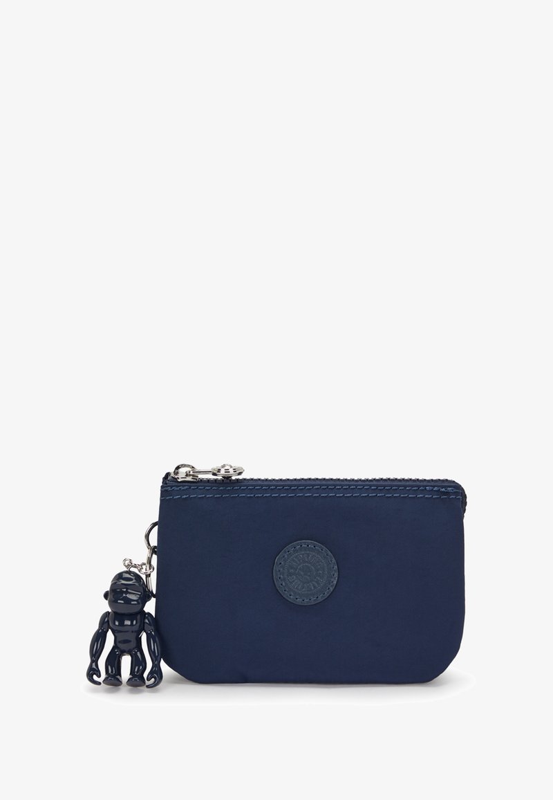 Laavapetan navy blue nylon pouch me zipper closure, ye round logo ek black monkey charm jise silver chain se juda hua hai.