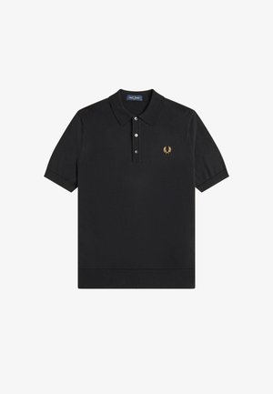 Camiseta polo negra de manga corta con cuello, tres botones y pequeño logotipo de corona de laurel amarilla en el lado izquierdo del pecho.