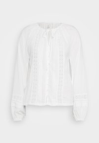 Hvit bluse med lange ermer laget av lett stoff. Har knappestolpe foran, intrikate broderidetaljer og rynkede mansjetter.