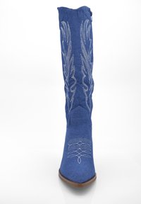 Bota vaquera azul con puntera afilada, material de mezclilla, costuras decorativas en blanco y un caña alta con un diseño bordado.