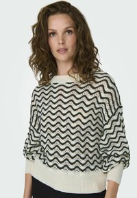 Maglione a righe ondulate in bianco e nero, caratterizzato da una vestibilità ampia, polsini a coste e un ampio scollo, realizzato in materiale leggero.