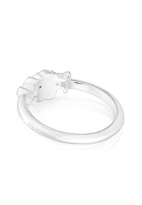 Anillo de plata con una banda lisa que presenta una figura estilizada de oso como elemento central de diseño, superficie pulida y reflectante.