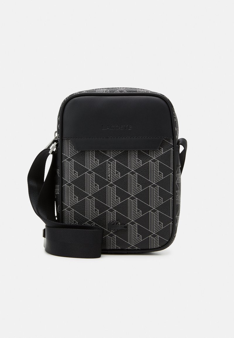 Black crossbody bag with a geometric pattern. Made of textured material, featuring a smooth top panel and adjustable strap.
