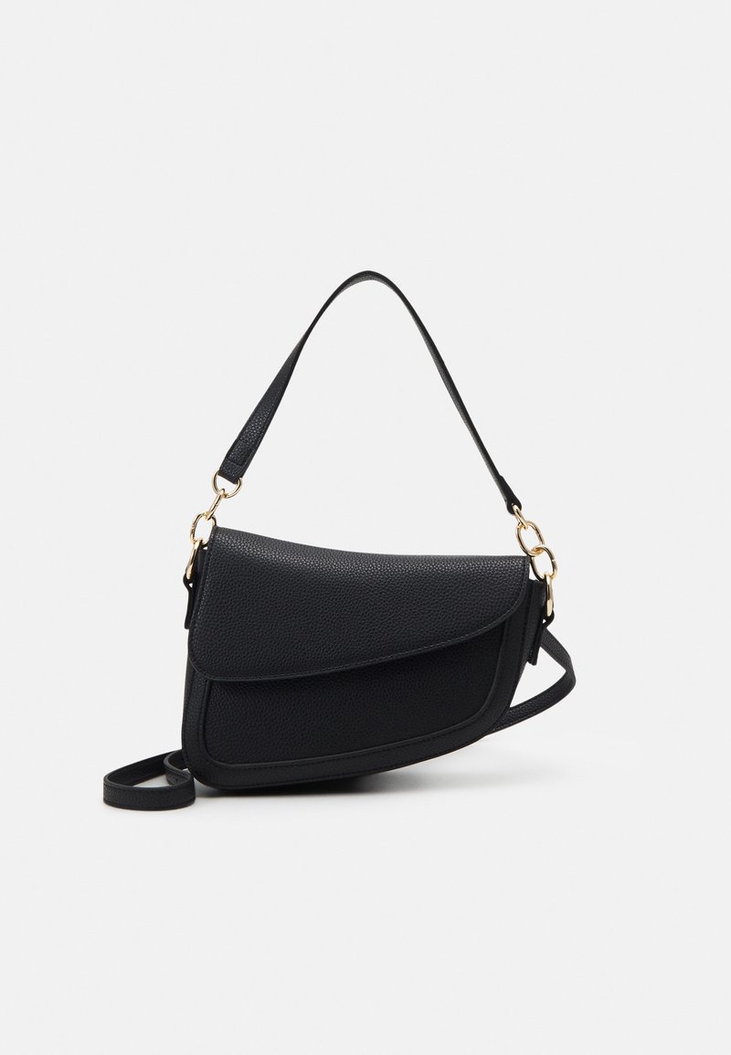 Sac à bandoulière en cuir noir texturé avec rabat incurvé et anneaux métalliques dorés sur les attaches de la lanière, sur un fond clair uni.