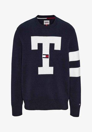 Pull en maille bleu marine avec un grand logo "T" blanc sur le devant, comprenant des accents rayés blancs sur les manches et des poignets côtelés.