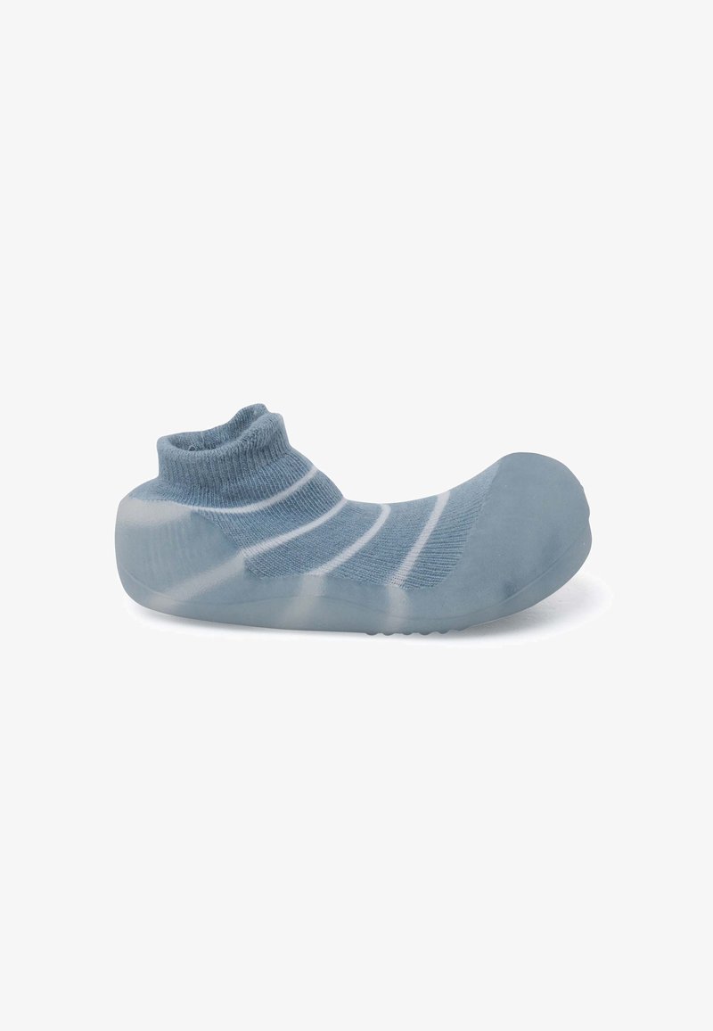 Blauwe sokschoen met een geribbelde boord, voorzien van een gladde, doorschijnende rubberen zool en witte strepen op de stof. Kenmerkend laag uitgesneden ontwerp.