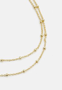 Collier en or avec un design de chaîne délicat, arborant de petits accents de perles rondes réparties uniformément tout au long des maillons.