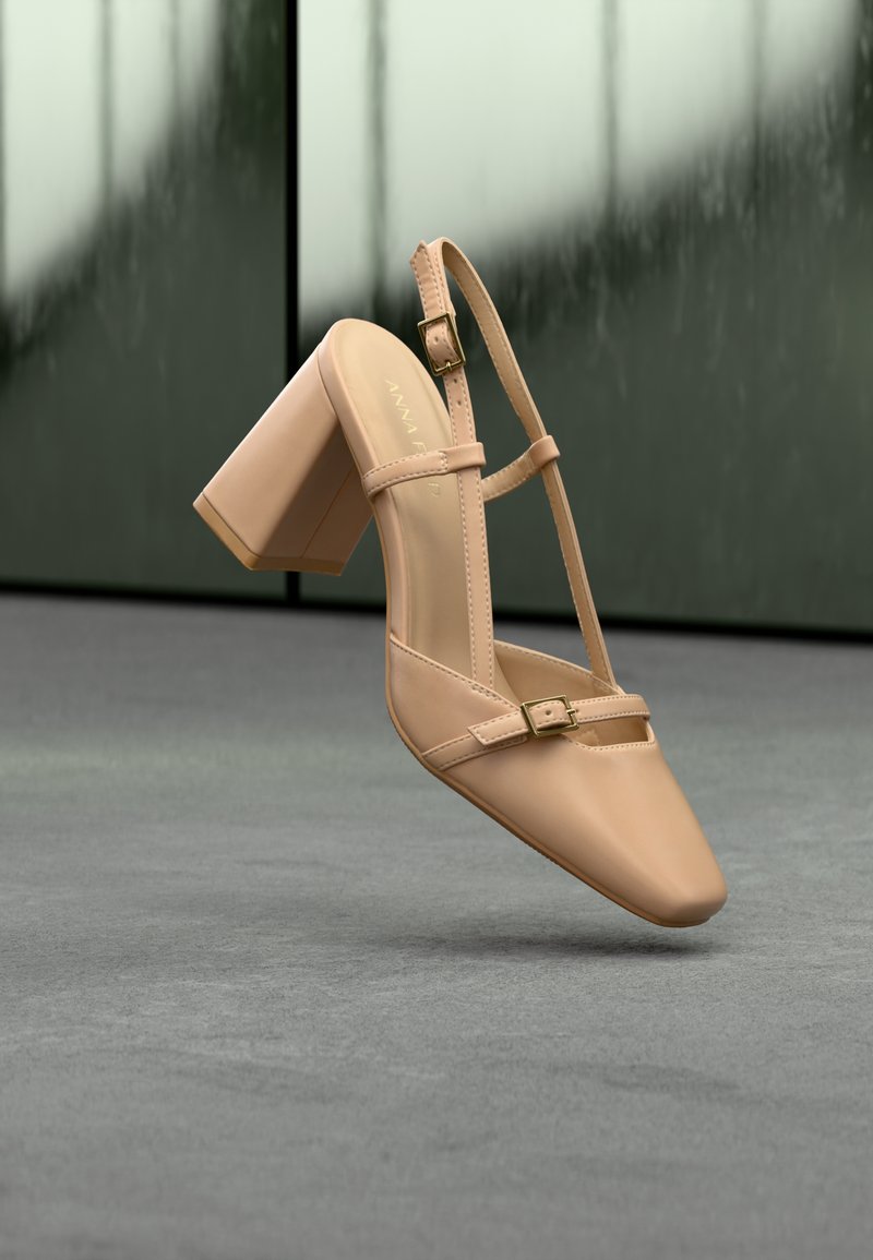 Chaussure à talon bloc couleur chair avec bout pointu, brides réglables à la cheville et détail de boucle plate. Texture en cuir lisse.