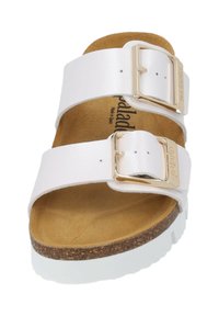 Vita sandal i vitt med två breda remmar, gyllene spännen, en korkmellansula och en strukturerad brun fotbädd. Sulan är vit med en lätt plattform.