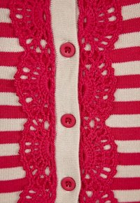 Cardigan a maglia con strisce orizzontali bianche e rosa, caratterizzato da un dettaglio centrale in pizzo, quattro bottoni rosa e una texture morbida.