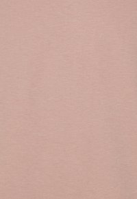 Světle růžové tričko vyrobené z měkké a hladké bavlny s texturovaným povrchem; má klasický kulatý výstřih a krátké rukávy.