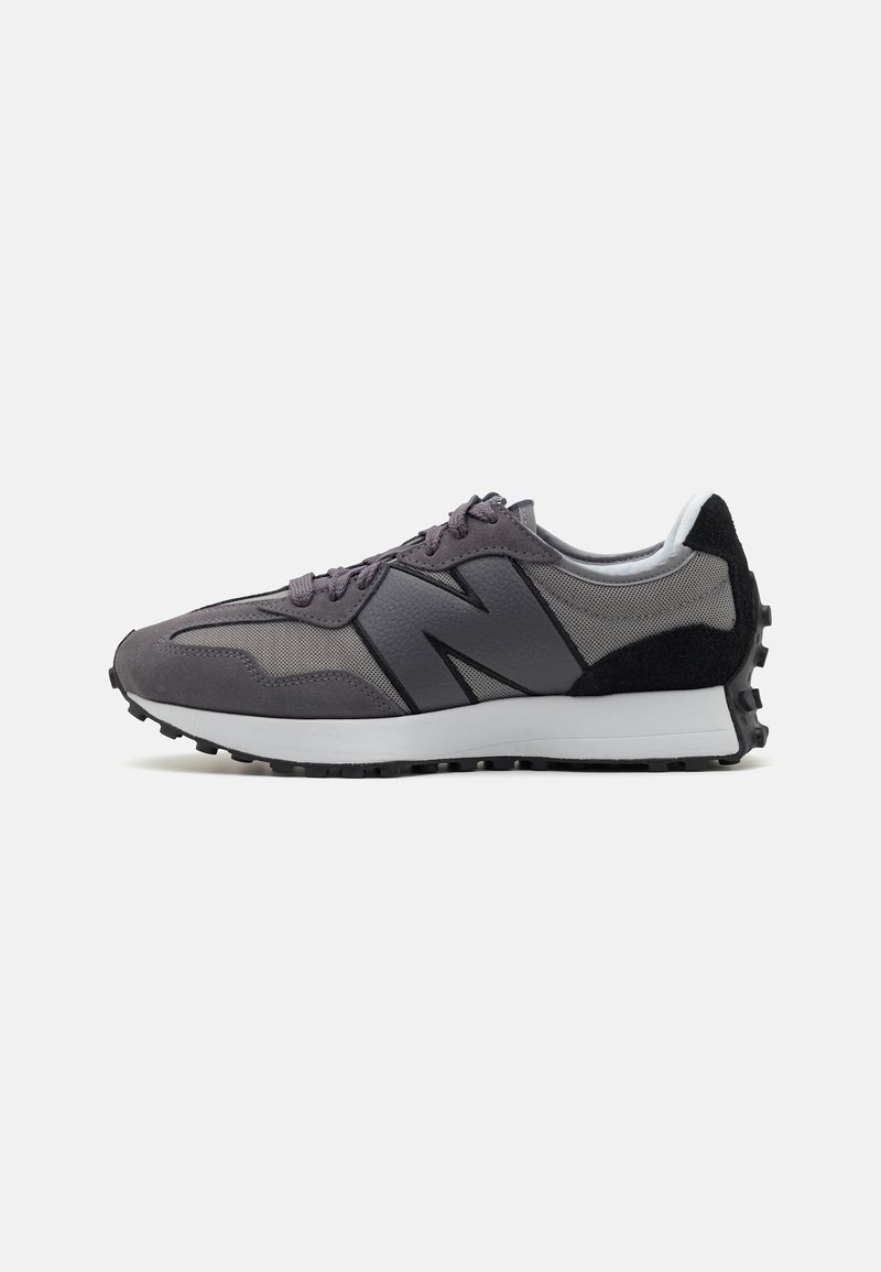 Baskets New Balance grises et noires avec panneaux en suède et mesh, grand logo « N » sur le côté, semelle intermédiaire blanche et semelle extérieure noire texturée.