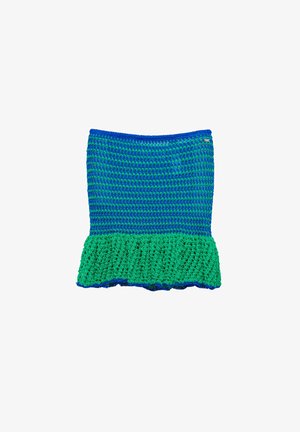 Jupe en crochet bleue et verte avec un ourlet vert à volants, présentant des rangées de points bleus et verts alternés et une petite étiquette métallique sur le bord supérieur.