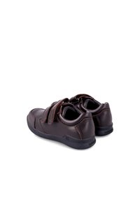 Zapatos de cuero marrón con dos correas de Velcro. Forma redondeada, superficie texturizada y suela de goma negra con un sutil detalle de marca.