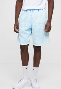 Lyseblå shorts med et marmor mønster, elastisk talje og sidelommer. Sæt sammen med hvide sneakers og ankelstrømper.