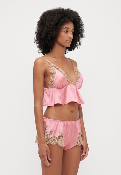 Roze satijnen pyjama set met een met kant afgewerkte bralette en bijpassende shorts met kanten accenten op de zoom, zachte textuur en verstelbare bandjes.