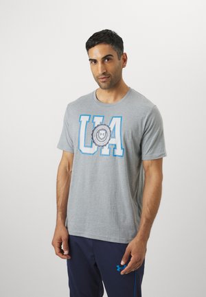 Grå bomulds t-shirt med rund halsudskæring. Har iøjnefaldende blå "UA" bogstaver og et rundt logo i midten. Korte ærmer, afslappet pasform.