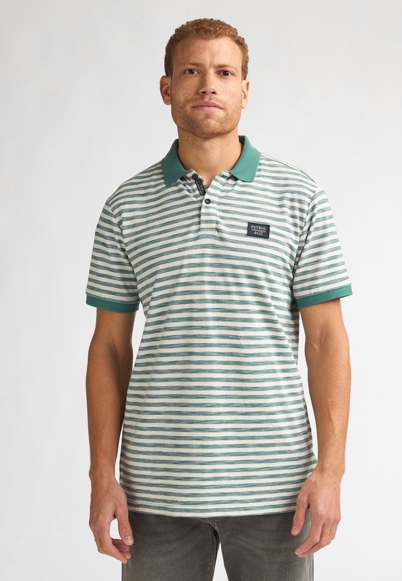 Polo rayé avec des rayures horizontales vertes et blanches, un col vert, des manches courtes et un petit logo sur la poitrine.