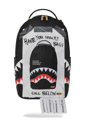 Zaino nero con design a denti di squalo e grafica centrale dello stesso zaino con nastro adesivo con la scritta "Hai visto la mia borsa?" e "Chiama sotto".