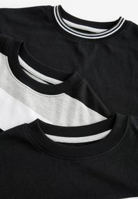 Trois t-shirts col rond empilés : un noir uni, un noir avec des rayures grises et blanches, et un gris uni, tous avec des cols côtelés.