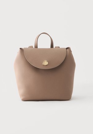Beige læderrygsæk med en buet klap og lille gylden cirkulær lås, med topgreb og justerbare skulderremme.
