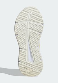 Suola di sneaker in gomma bianca con un motivo testurizzato, caratterizzata da un design a zig-zag e un logo Adidas. Ritaglio centrale per flessibilità.