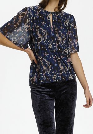 Lockere blaue Bluse mit einem gemischten Muster in Brauntönen, Rosa und Blau. Hat kurze Puffärmel und einen Schlüsselloch-Ausschnitt mit einem Knopfdetail.