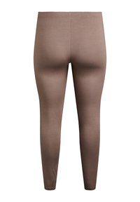 Leggings marroni realizzati in un tessuto elastico, con un design aderente, una texture liscia e un cinturino semplice senza dettagli visibili.