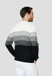 Pulover tricotat cu gât rotund, având dungi orizontale în alb, gri și negru. Material texturat și mâneci mulate.