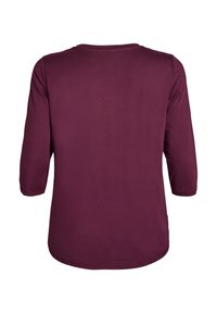 Burgunderfarbenes Langarmshirt mit rundem Halsausschnitt, weicher Textur und lässigem Schnitt. Verfügt über Dreiviertelärmel und einen abgerundeten Saum am unteren Ende.