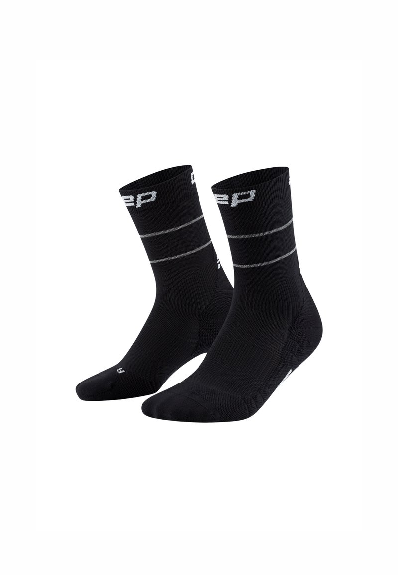 Calcetines deportivos negros con textura acanalada, que presentan rayas horizontales grises y un logo, diseñados para comodidad y rendimiento.