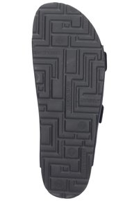 Black rubber shoe sole featuring a maze-like tread pattern with circular accents, designed for traction and durability.