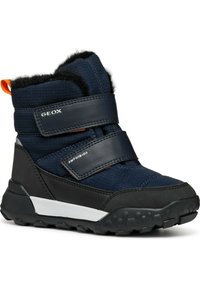 Botas impermeables azul marino con parte superior de textil, suela de goma negra y correas de velcro. Presentan un forro de piel sintética y acentos blancos en contraste.