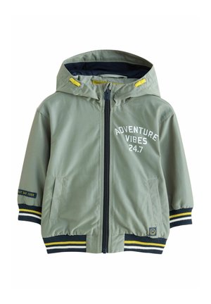 Jasnozielona dziecięca kurtka z kapturem, z przednim zamkiem błyskawicznym, paskowanymi mankietami, kieszeniami oraz białym napisem "ADVENTURE VIBES 24.7" na piersi.