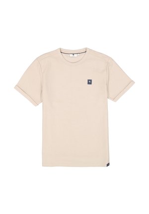 Beige cotton t-shirt with short sleeves, round neckline, and navy logo patch on left chest. Smooth texture and rolled sleeve cuffs.
