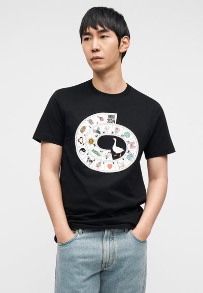 Μαύρο βαμβακερό t-shirt με κυκλικό γραφικό που περιλαμβάνει πολύχρωμα εικονίδια, όπως ένα χήνα, ήλιο, σύμβολο ειρήνης και καρδιές. Κανονική εφαρμογή.