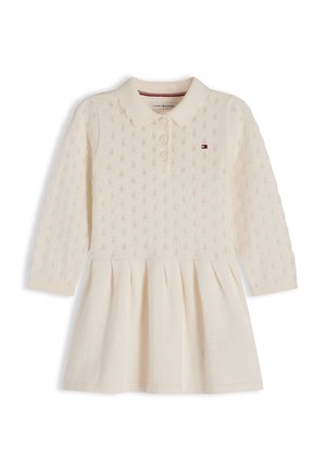 Vestito in maglia color crema a maniche lunghe con collo polo, patta con bottoni, motivo lavorato sulla parte superiore, gonna plissettata e piccolo logo Tommy Hilfiger sul petto.