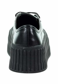 Czarne sneakersy z gładkiej skóry, z grubą gumową podeszwą z rowkami i szerokim obcasem. Posiadają sznurowanie oraz zaokrąglony kształt czubka.