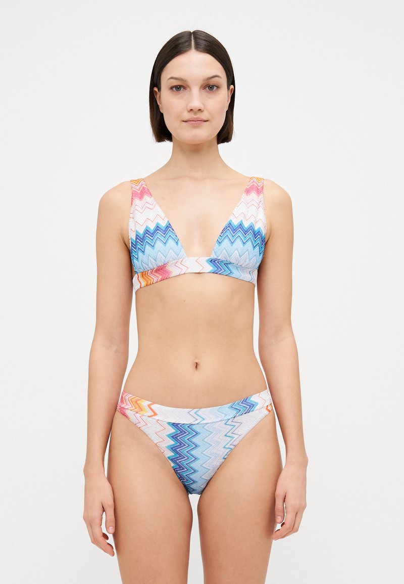 Bikini komplektas su zigzago raštu pastelinių rožinės, mėlynos ir oranžinės spalvų. Pagamintas iš lygaus audinio, su trikampiu liemenėliu ir derančiais apatiniais.