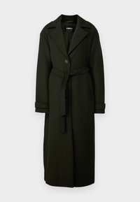 Μακριά σκούρα πράσινη παλτό φτιαγμένο από υφαντό ύφασμα. Διαθέτει περιλαίμιο με εγκοπή, κλείσιμο με έναν μονό κουμπί και αντίστοιχο ζώνη στη μέση.