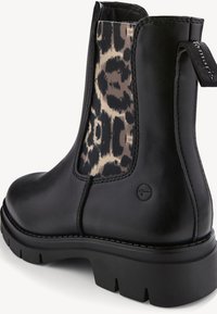 Svart läderankelboot med leopardmönstrad elastisk sida, chunky svart sula och en dragflik för enkel påtagning. Har dekorativ sömnad.