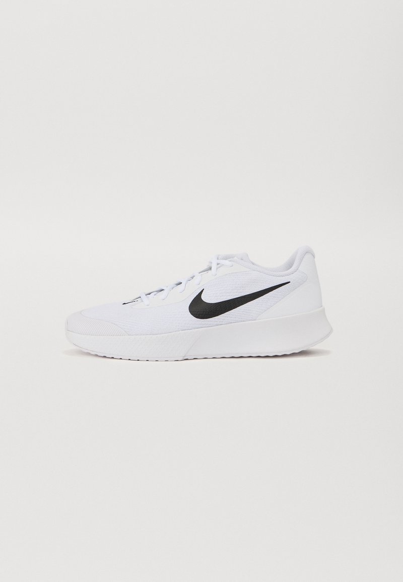 Bílé sportovní tenisky s bílými tkaničkami a černým logem Nike swoosh na boku, vystavené na bílém pozadí.
